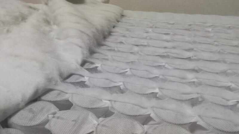 スプリングマットレスの布部分を剥がしている様子