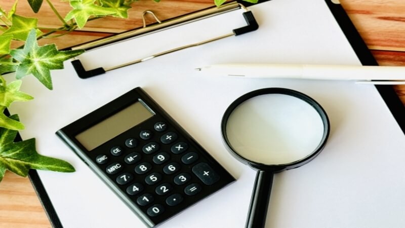 バインダーと電卓、ぺん、虫眼鏡